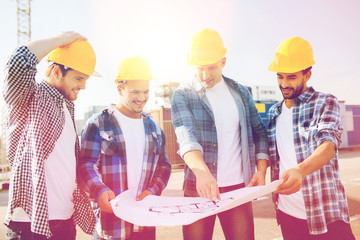 group of builders with tablet pc and blueprint