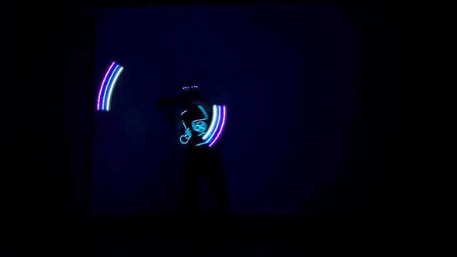 Man twists fiery circles on a light show.