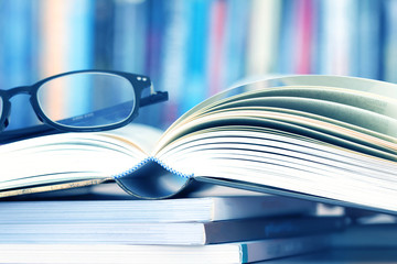 Close up opened book page and reading eyeglasses 