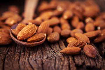 close up Peeled almonds nut in spoon on wooden  background