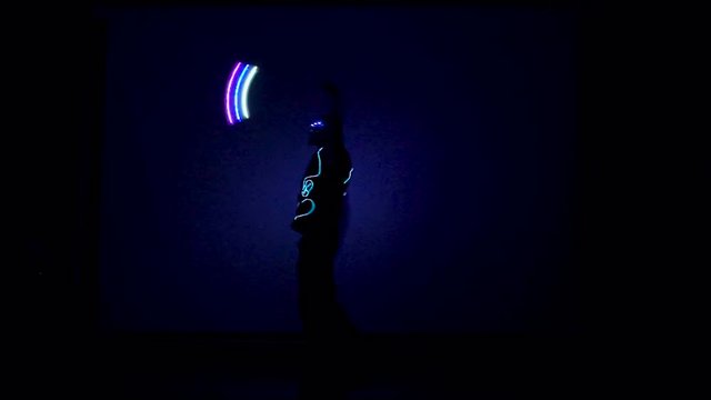 Man twists fiery circles on a light show.