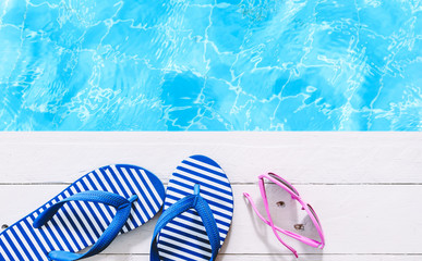 flip-flops and sunglasses on the swimming pool