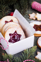 Christmas or New Year homemade sweet present in white box. Traditional Austrian christmas cookies - Linzer biscuits filled with red raspberry jam. Festive decoration