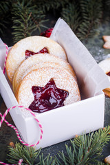 Christmas or New Year homemade sweet present in white box. Traditional Austrian christmas cookies - Linzer biscuits filled with red raspberry jam. Festive decoration