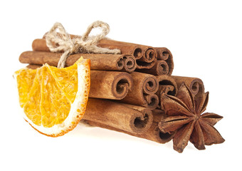 Dried orange, anise and cinnamon sticks isolated on white backgr