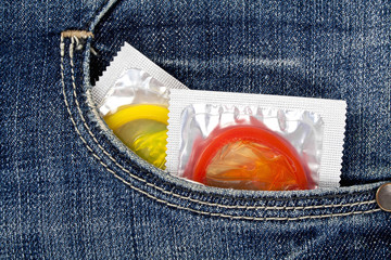 Colored condoms in a blue jeans pocket