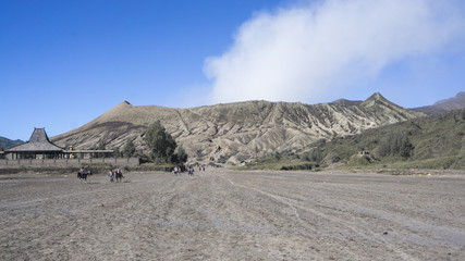 Landscape Man ride a horse go to Bromo volcano while eruption, Java, Indonesia,soft focus and motion blur