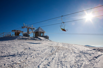 Ski lift in winter snowy mountain on sky background