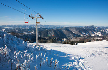 Ski lift in winter snowy mountain on sky background