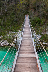 Wooden bridge the turquoise green Soca river in Slovenia