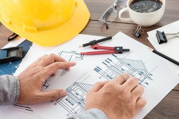 Architect working with construction tools and helmet safety on wooden table