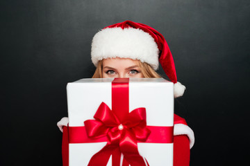 Woman in red santa claus dress giving big gift box