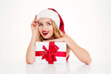 Happy woman in santa claus costume holding with present box