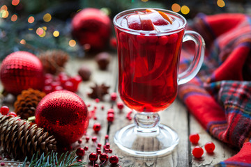 Christmas hot cranberry mulled wine, orange pomegranate punch or sangria in a rustic wooden table. Closeup. Christmas decorations.