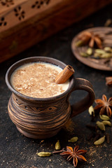 Masala pulled tea chai latte hot Indian sweet milk spiced drink, nutmeg, fresh spices and herbs blend, anise organic infusion healthy wellness beverage teatime ceremony in rustic clay cup
