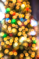 Colorful bokeh christmas lights background from a christmas tree with lights and xmas balls....