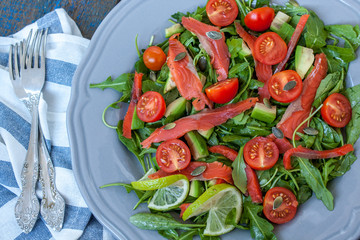 Salted salmon with herbs, tomatoes and salad on a wooden board. Love for a healthy raw food concept