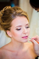 
Wedding preparation. Professional makeup lipstick bride