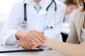 Hand of doctor reassuring her female patient