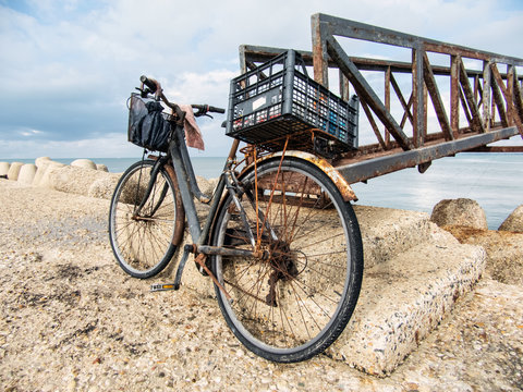 Vecchia bicicletta arrugginita abbandonata sul molo