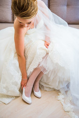 Beautiful charming bride wears shoes