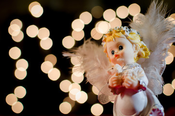 Christmas card. Angel on the bright blurred Xmas lights backgrou