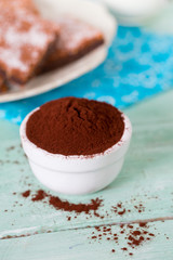 cocoa powder and brownies on background