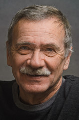Portrait of an elderly man with a kind smile.