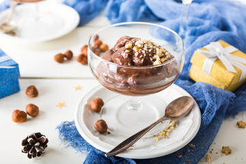 Chocolate pudding mousse with avocado, nuts and holiday decorations. Delicious Christmas themed dinner table.