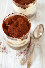 tiramisu in glass on wooden surface