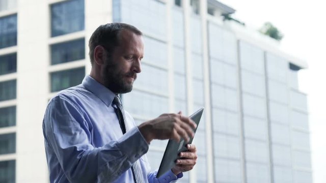 Young businessman using tablet by standing on terrace
