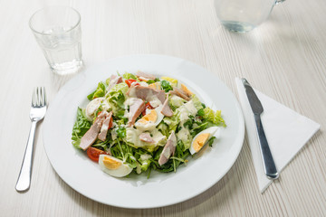 Nutritious vegetable salad with boiled egg slices and salmon