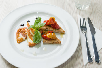 Delicious toast sandwiches with fried cheese, tomatoes, olive oil and basil
