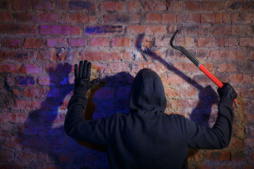 Burglar standing with raised arms