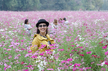 Portrait of thai women at the beautiful cosmos flowers field.