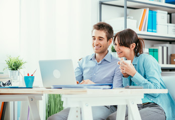 Smiling couple using a laptop