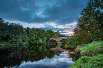 Fototapeta na wymiar River North Tyne flows under Bellingham Bridge, at the Market Town in Northumberland, which is the first town on the North Tyne below Kielder Reservoir
