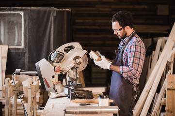 profession, carpentry, woodwork people concept - carpenter with wood plank and notebook checking...
