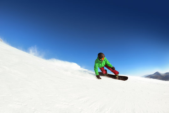 Man snowboarder rides slope sheregesh. Space for text