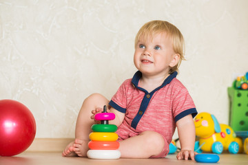 Year-old child playing with educational cup toys at home