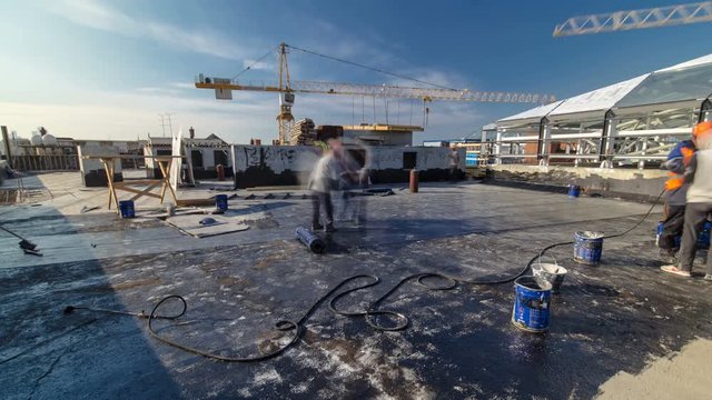 Roofer installing Roofing felt with heating and melting of bitumen roll by torch on flame during roof repair timelapse