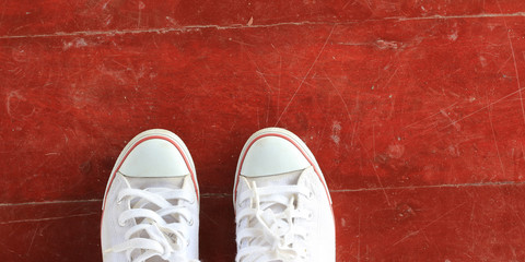 Top view of old white sneaker on wooden floor