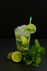 Fresh mojito cocktail on black background. Mojitos with mint leaves, lime and ice