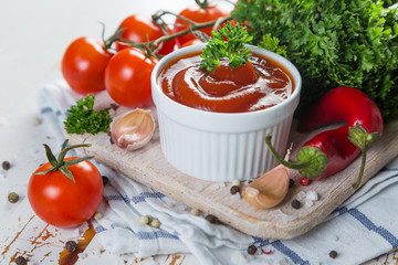 Ketchup and ingredients on wood background