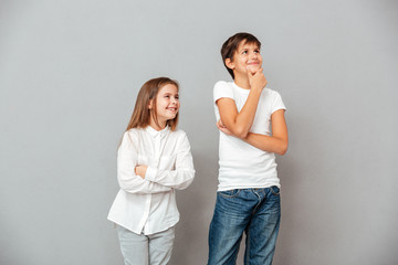 Two happy pensive children standing and looking away