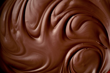 Melted chocolate swirl background. close up.