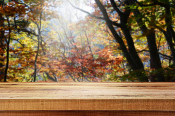 Naklejka na ściany i meble Wooden table and blur autumn background.
