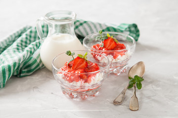 summer breakfast - cottage cheese with strawberry in a glass bowl on a table, selective focus