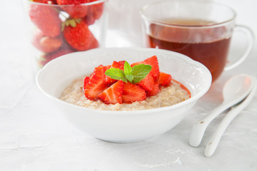 porridge with strawberry on a table, selective focus