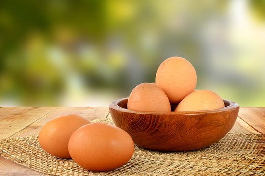 Eggs on wooden table and blur nature background.